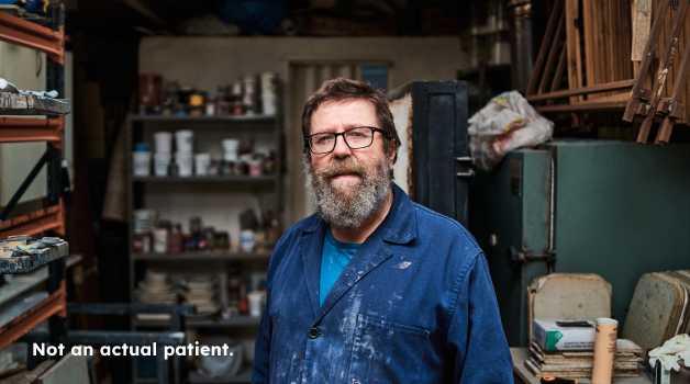 Middle-aged man in his workshop staring at the camera