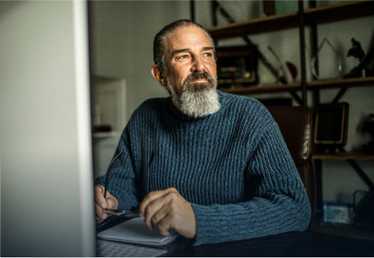 Older man sitting with gaze directed away from camera