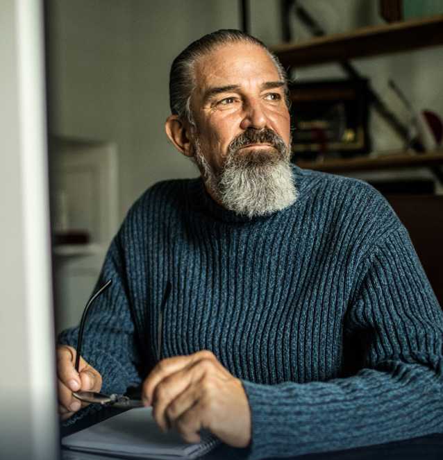 Older man sitting with gaze directed away from camera