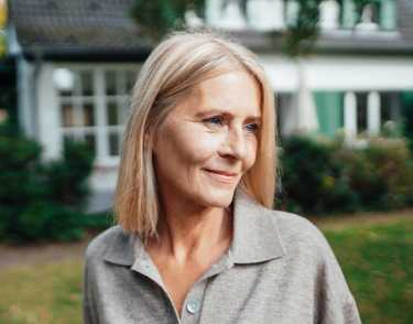 Middle-aged woman smiling looking away from camera